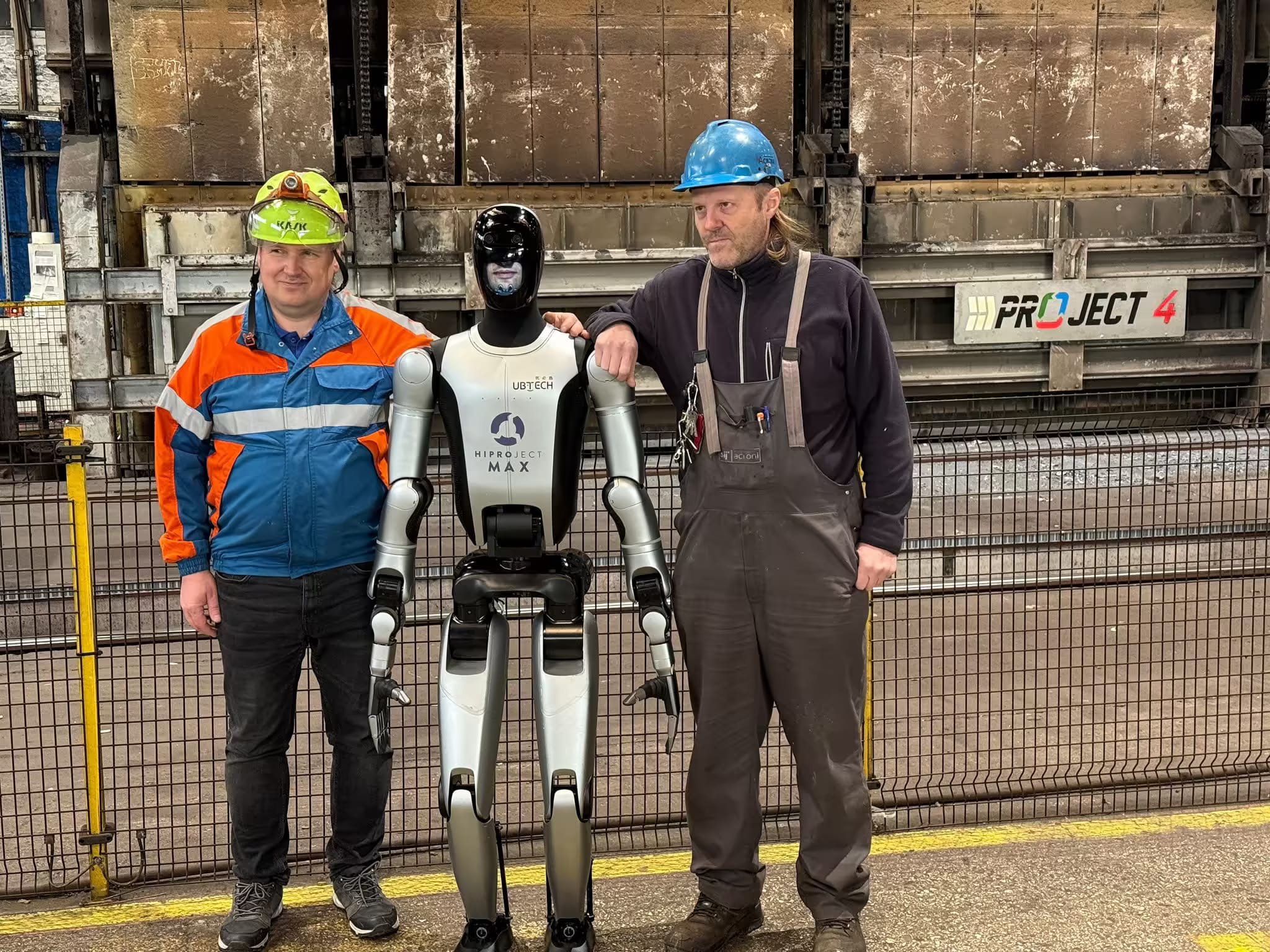 MAX mit zwei Arbeitern vor einem Industrieofen.