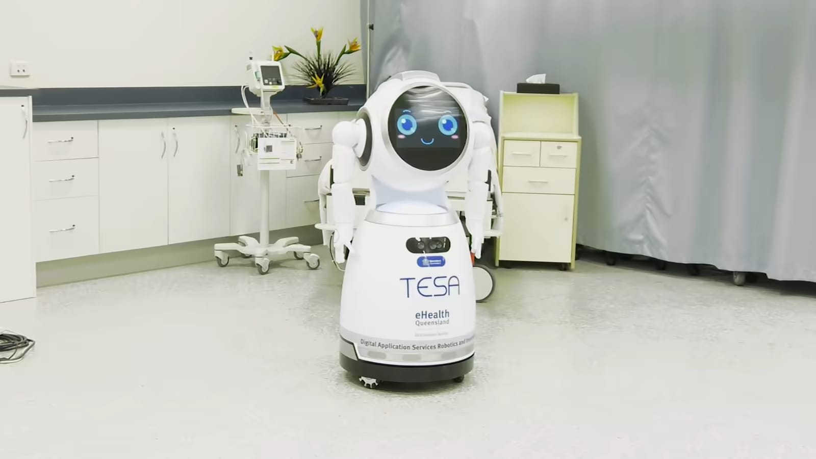 Un robot CRUZR de pie en una habitación de hospital junto a equipamiento médico.