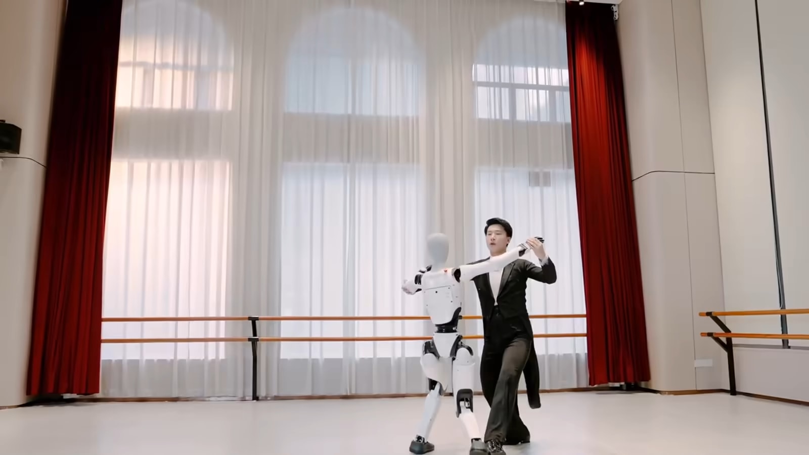 Der humanoide Roboter Walker C1 tanzt mit einem Balletttänzer in einem Probensaal, Aufnahme des Herstellers UBTECH