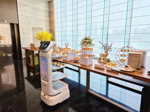 Робот CADEBOT уз сто са храном код панорамског прозора