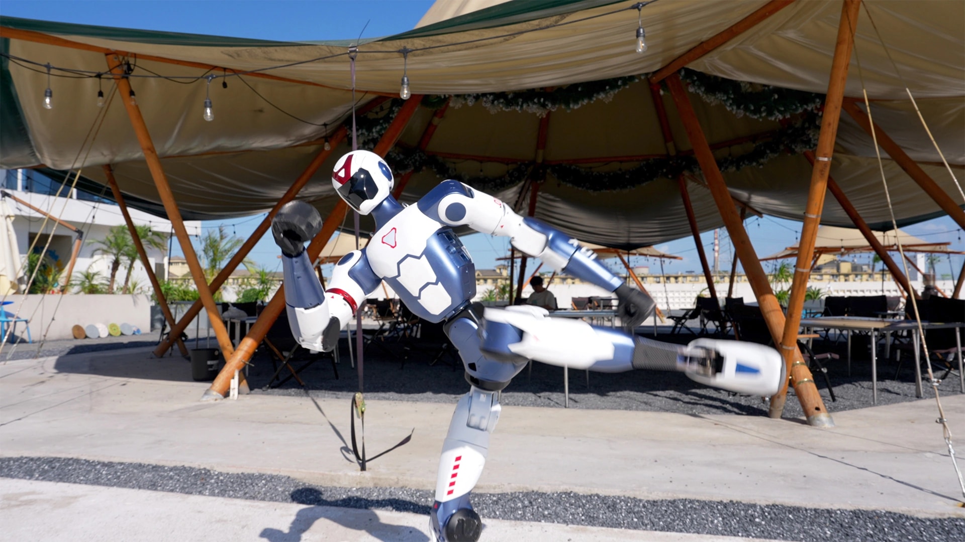 Der Roboter R1 übt Schläge unter einem Zeltdach