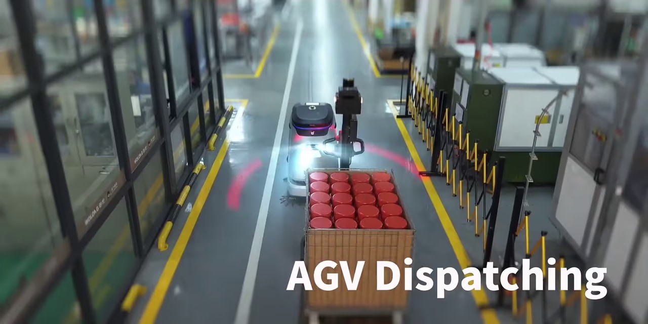 Pogled na proizvodno halo z vozili AGV (angleški napis na kadru)