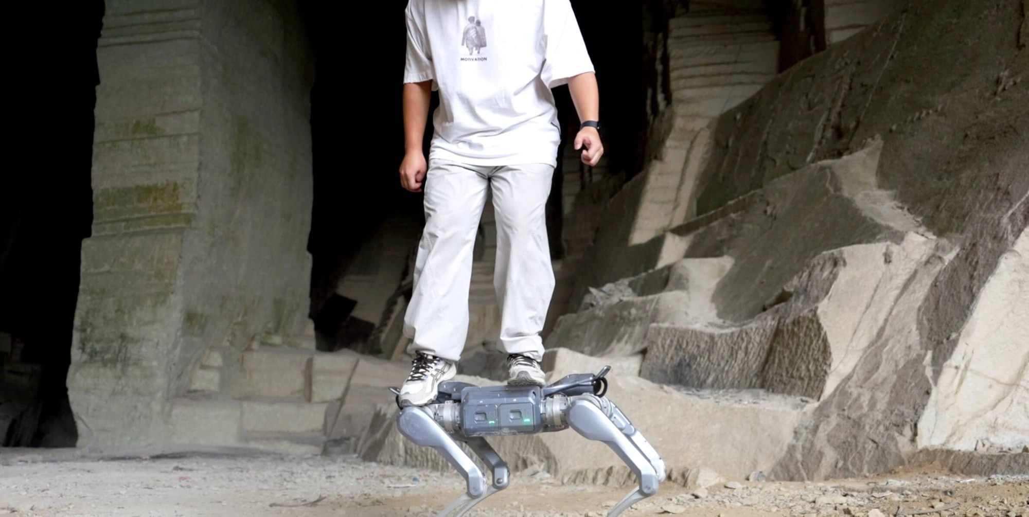 Robot As2 stopa po kamnitih blokih ob osebi